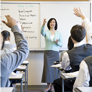 教室で手を挙げる教師と生徒